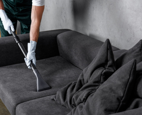 cropped shot of man in rubber gloves using vacuum cleaner and cl